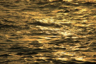 Deniz dalgaları gün batımında suda 