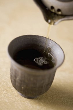 Ahşap masa arkasındaki çay fincanının yakın görüntüsü.