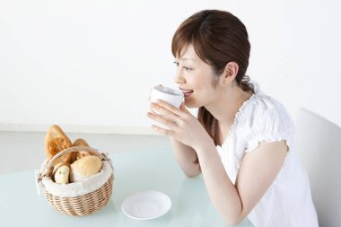 Masada kahve içen Asyalı kadın. 