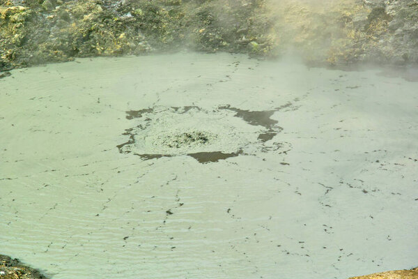 beautiful view of hot spring with green mud and steam