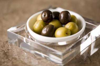 Bir kasedeki yeşil ve siyah zeytin manzarasını kapat.  