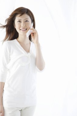 Cep telefonuyla gülümseyen Asyalı kadın portresi 