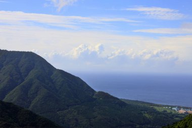 Yeşil tepelerin ve deniz kıyısının güzel manzarası      