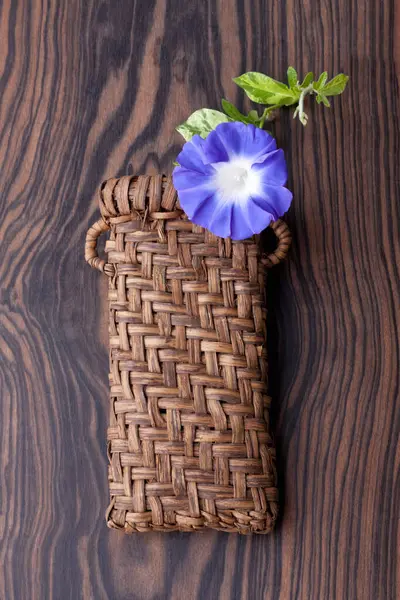Ένα Μπλε Λουλούδι Μια Παλιά Τσάντα Ένα Ξύλινο Τραπέζι — Φωτογραφία Αρχείου