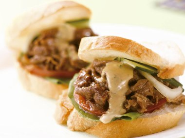 Peynirli, soslu ve soğanlı etli sandviç.