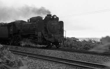 Motoru tarafından yönetilen konvansiyonel tren Japon şehri boyunca kasıtlı olarak hareket eder..