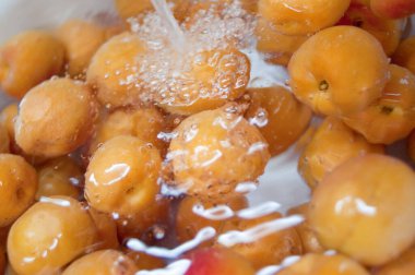 Taze olgun organik şeftalilerin suyla yakın plan görüntüsü.    