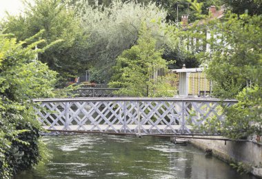 Kanal üzerinde köprüler ve şehirde binalar olan güzel bir park manzarası.