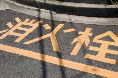 Asfalt yolundaki sarı trafik işaretlerinin gündüz görüntüsü