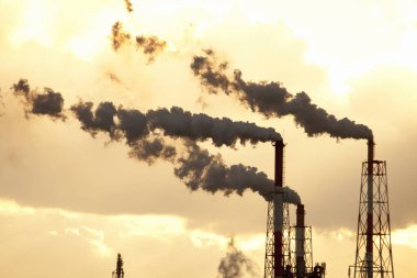 Gün batımına karşı boruları olan endüstriyel fabrika       