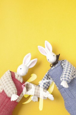 Sarı arka planda sevimli oyuncak tavşanlar, el yapımı konsept. 