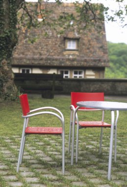 Yağmurdan sonra arka bahçede boş sandalyeler ve yuvarlak masa