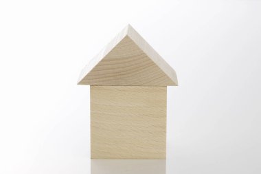 Beyaz arka planda izole edilmiş ahşap oyuncak ev modeli. Emlak kavramı.