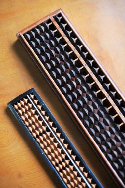 İki geleneksel ahşap abaküs kahverengi masa yüzeyinde dinleniyor.