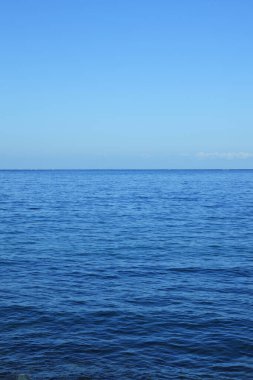 Beyaz dalgalı mavi su ve ufuk çizgisi.