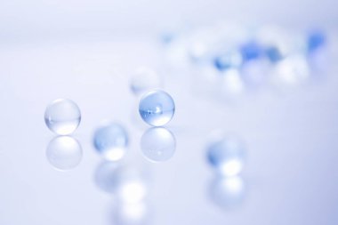 Yüzeyinde yansıması olan mavi şeffaf cam toplar.