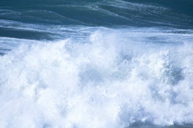 Denizdeki dalgaların gündüz görüntüsü. Denizin üzerindeki mavi gökyüzü