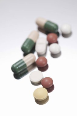 Beyaz arkaplanda hapların ve kapsüllerin yakın plan görüntüsü     