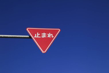 Mavi gökyüzüne karşı kırmızı yol işareti 