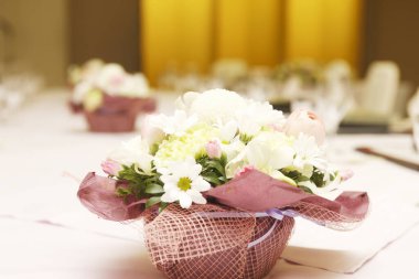 Restoran masasında çiçekli güzel buketler.