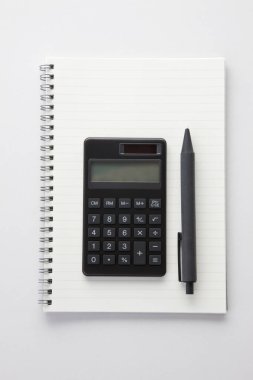 beyaz bir tablo üzerinde boş bir sayfa ile not defteri ve hesap makinesi