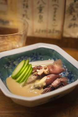 Seramik kasede servis edilen dilimlenmiş salatalık ve kalamar.