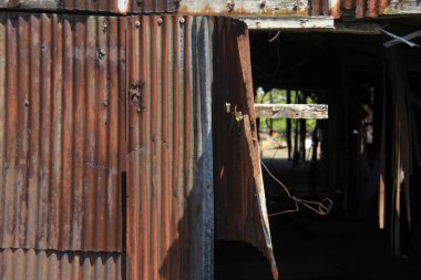 Eski bina yapısından sarkan paslı metal tabakalar