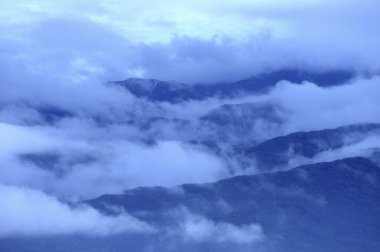 Sisli bir sabahta manzaralı dağların üstündeki bulutların havadan görünüşü 