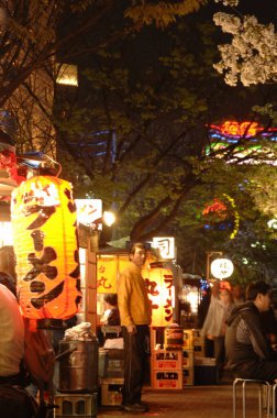 İnsanlar geceleri yemek tezgahlarının keyfini çıkarıyorlar.