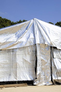 Arkaplanda büyük beyaz plastik çadır