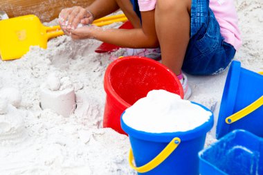 Kumda renkli kovalarla oynayan çocuk