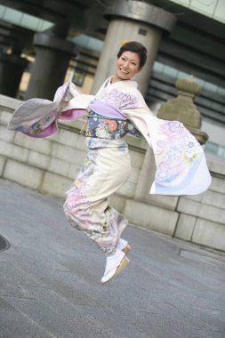 Geleneksel kimono giymiş, açık hava pozları veren çarpıcı bir Japon kadının portresi.