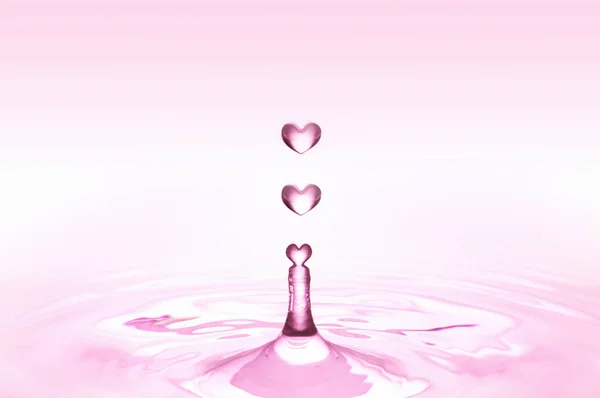 pink heart shaped water drops falling on water surface