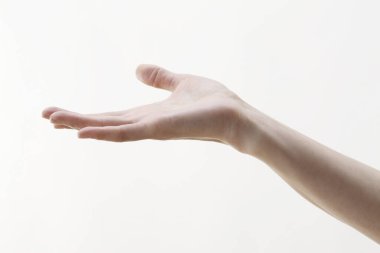 Genç bir kadının eli eliyle bir şey gösteriyor.