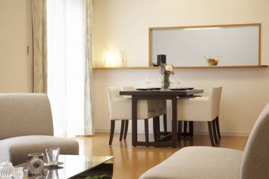 Modern oturma odası, iki kanepe, ahşap masa ve bej sandalyeler.