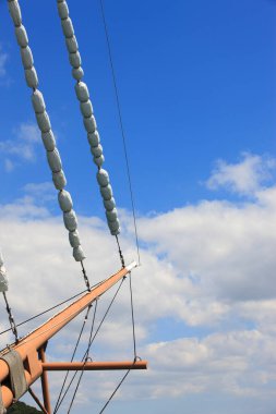 Bulutlu mavi bir gökyüzünde yelkenli