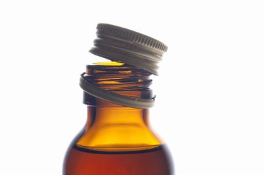 Beyaz arka planda açık kapaklı cam yağ şişesi.