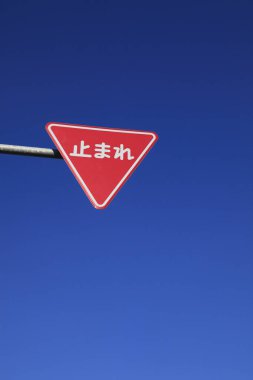 Mavi gökyüzüne karşı kırmızı yol işareti 