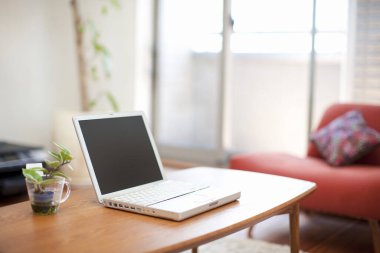 Modern oturma odasındaki masada dizüstü bilgisayar..