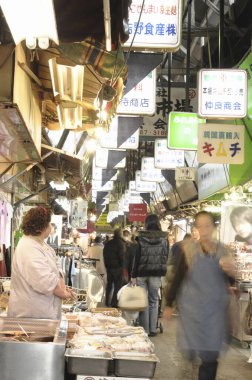 Kapalı alanda taze deniz ürünleri satmakla meşgul.