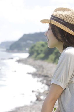 Denize bakan şapkalı genç bir kadının portresi 