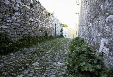 Eski kasabadaki taş evler arasında dar bir sokak.