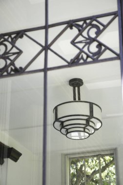 Geometrik pencere desenlerini yansıtan modern tavan lambası sabitlemesi