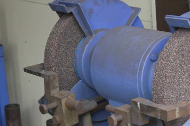 Yakın plan, atölyedeki endüstriyel mavi öğütme makinesini gösteriyor