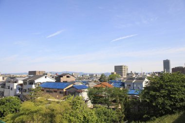 Japonya 'nın Osaka kentindeki yeşil bir parktan şehir merkezindeki yüksek katlı apartmanlar. 