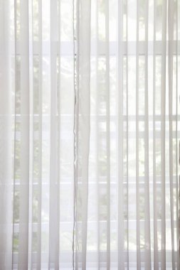 Penceresinden güneş ışığı geçen beyaz perdeler 