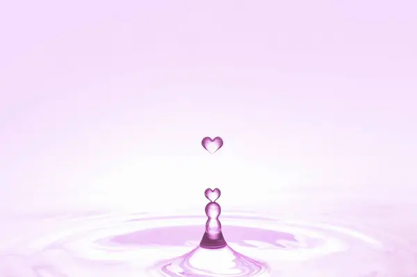Rosafarbene Herzförmige Wassertropfen Fallen Auf Die Wasseroberfläche — Stockfoto