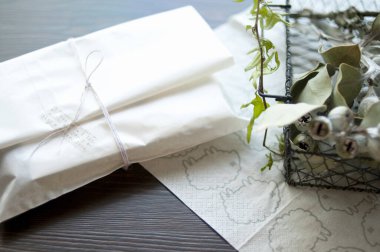 Dekoratif metal sepetin yanına katlanmış beyaz peçeteler.