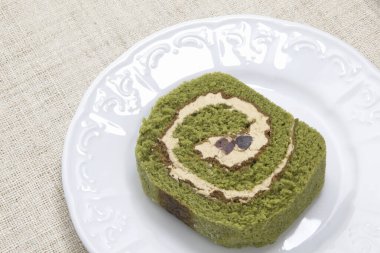Beyaz tabakta gurme Matcha Roll Pastası 'nın yakın plan görüntüsü       