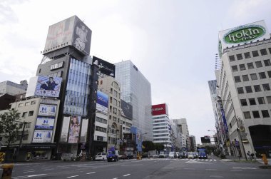 Yüksek binalar, hareketli bir Japon metropolünün güneşin öptüğü manzarasına hakim..